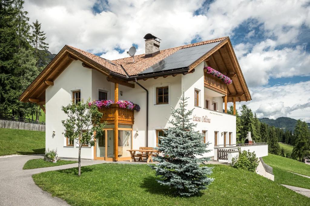 une maison avec un arbre de Noël en face dans l'établissement Ciasa Odlina, à La Villa