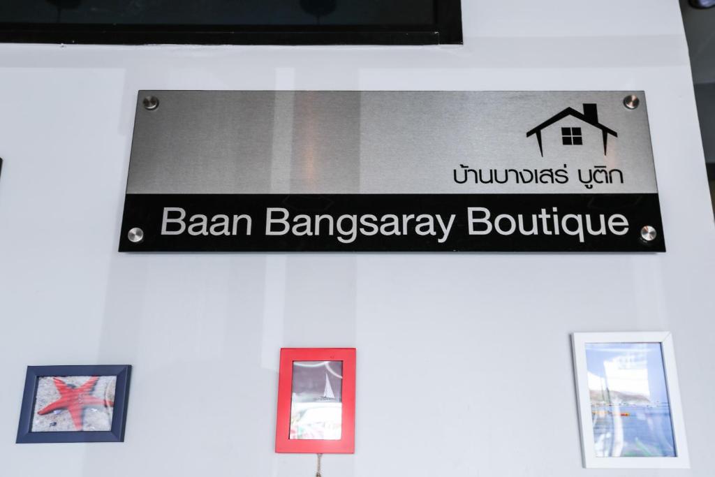 un panneau pour une boutique de foin bann sur un mur dans l'établissement Baan Bang Saray Boutique3, à Chonburi