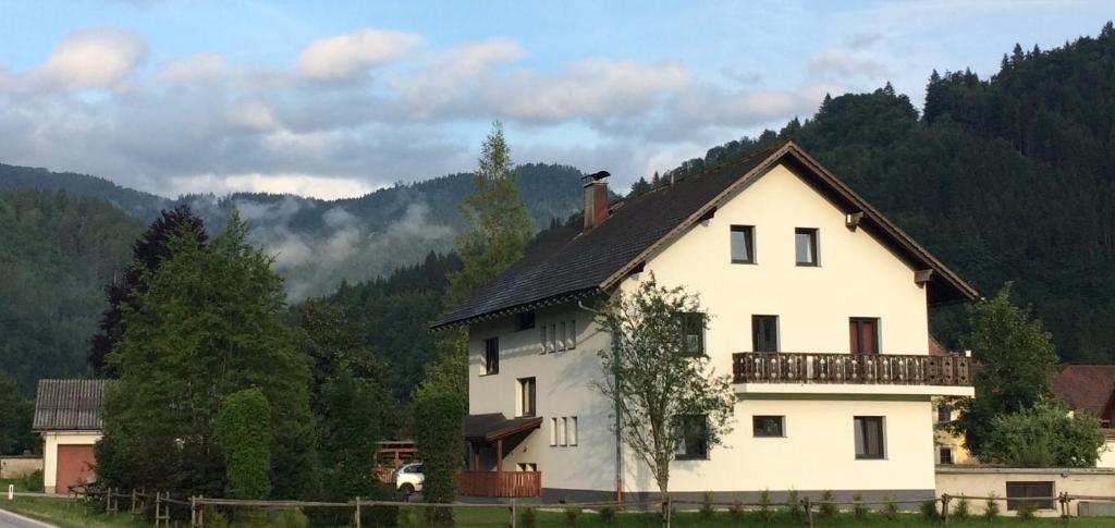 uma casa branca com uma cerca em frente a uma montanha em Löwenherz em Göstling an der Ybbs