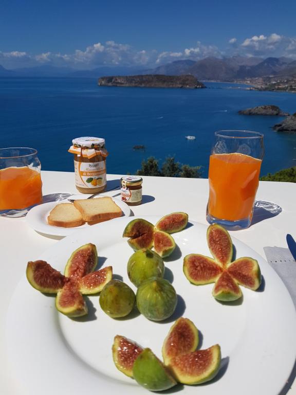 un piatto bianco con fichi e succo su un tavolo di Villa Crawford a San Nicola Arcella