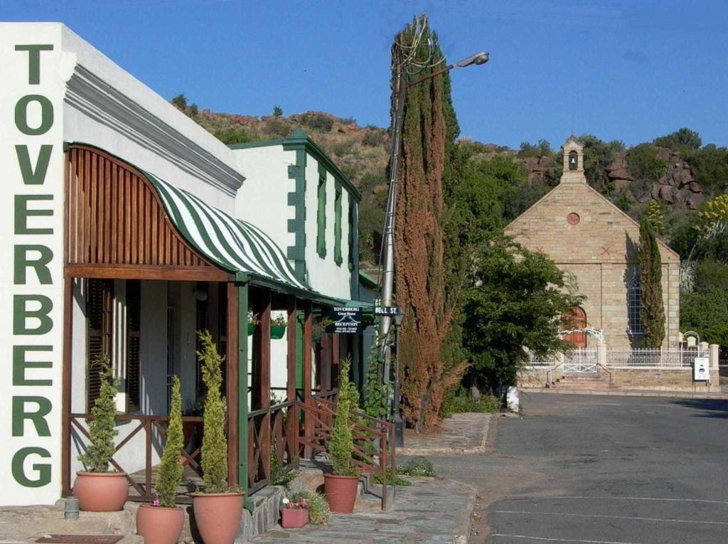 a building with potted plants on the side of a street at Toverberg Guest Houses in Colesberg