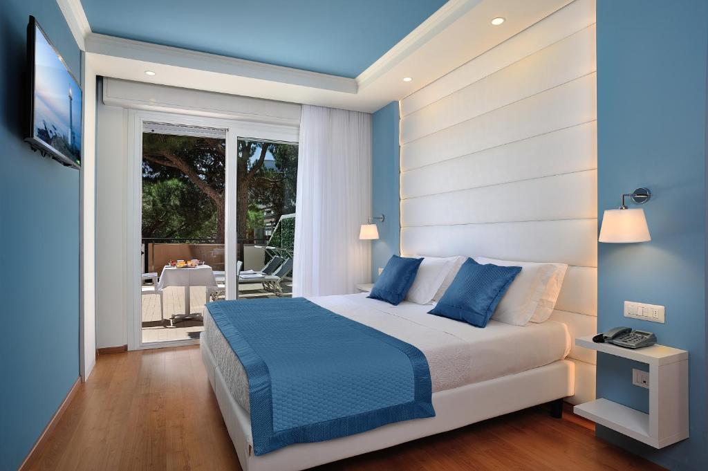 1 dormitorio con 1 cama y balcón con mesa en Hotel Concord en Riccione