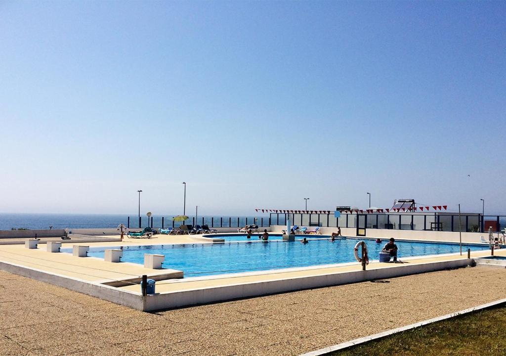 una grande piscina vicino all'oceano di Parque de Campismo Orbitur Canidelo a Vila Nova de Gaia
