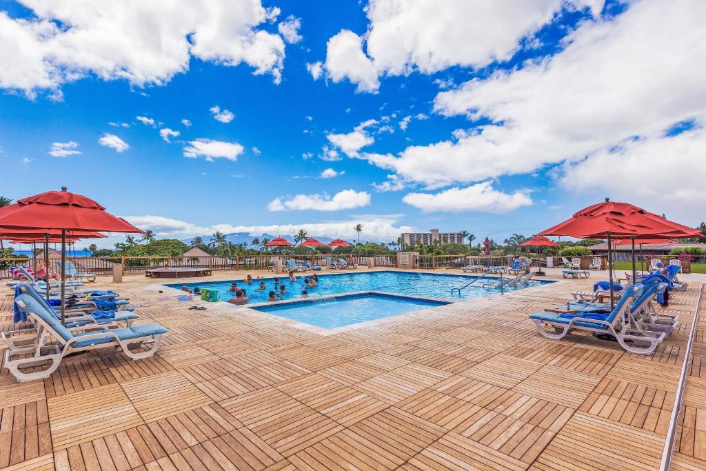 einen Pool in einem Resort mit Stühlen und Sonnenschirmen in der Unterkunft Maui Eldorado Resort in Kaanapali