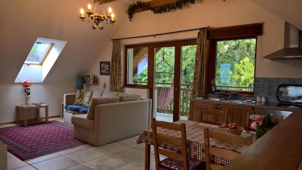 ein Wohnzimmer mit einem Sofa, einem Stuhl und einem Fenster in der Unterkunft Oak Tree Apartment - Tölgy Lak in Pilisszentkereszt
