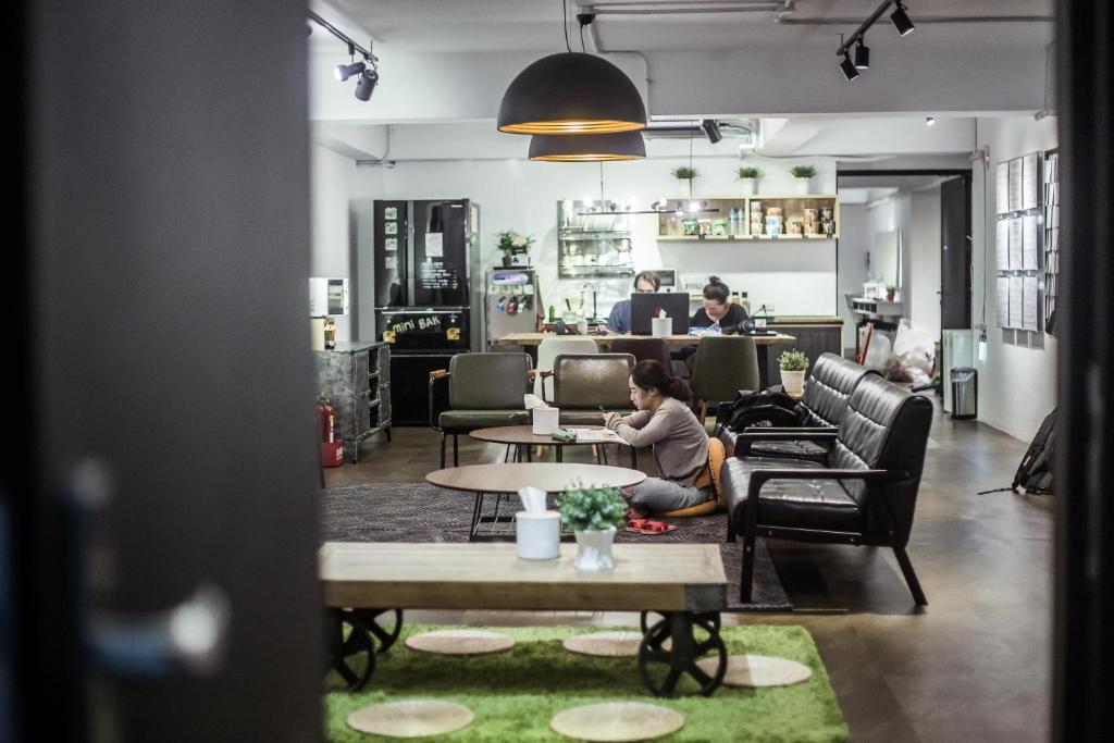 a person sitting at a table in a room at We Come Hostel in Taipei