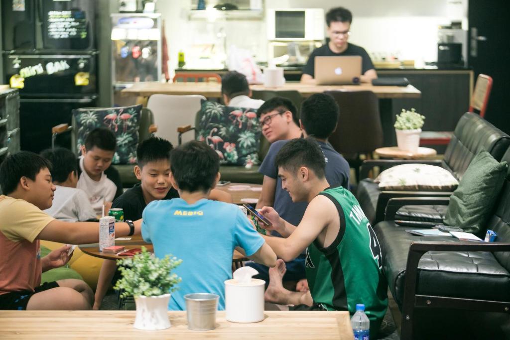 a group of people sitting at tables in a restaurant at We Come Hostel in Taipei