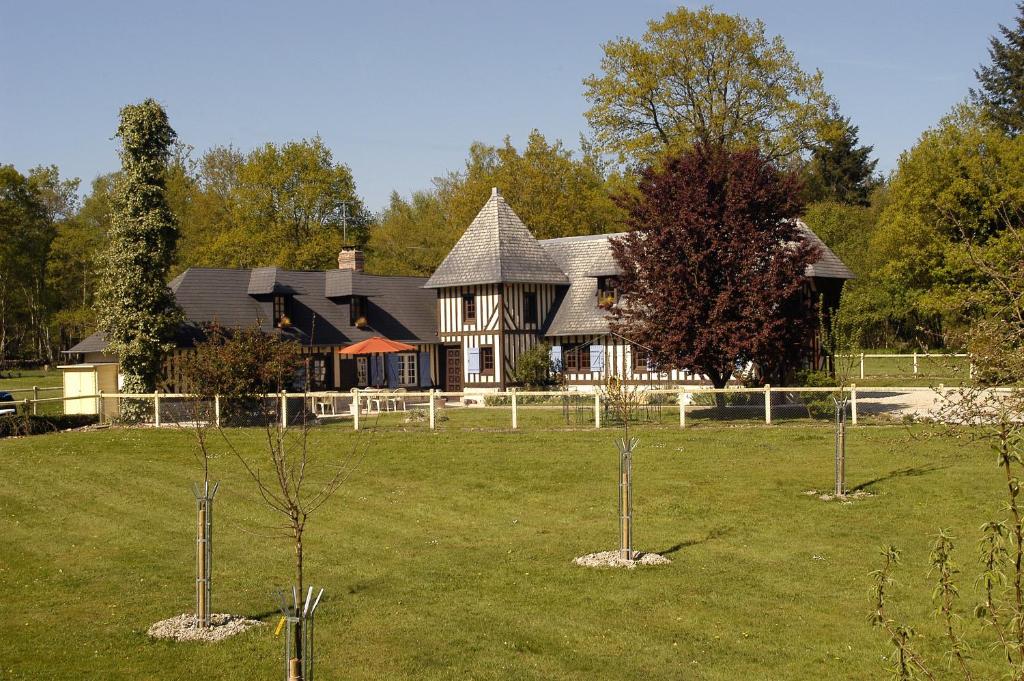 una casa con un patio con árboles delante de ella en Domaine de La Mésange, en Le Mesnil-Durand