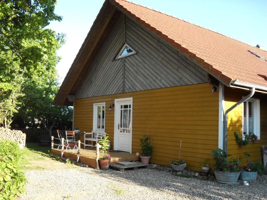 ein kleines gelbes Haus mit weißer Tür in der Unterkunft ostseeurlaub-asmussen in Gelting