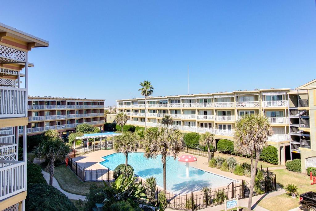 un complexe d'appartements avec piscine et palmiers dans l'établissement The Victorian, à Galveston