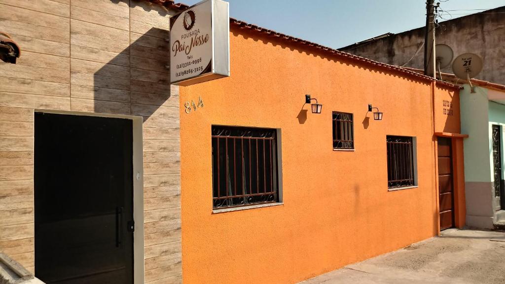 an orange building with a no parking sign on it at Pousada Pai Nosso in Aparecida