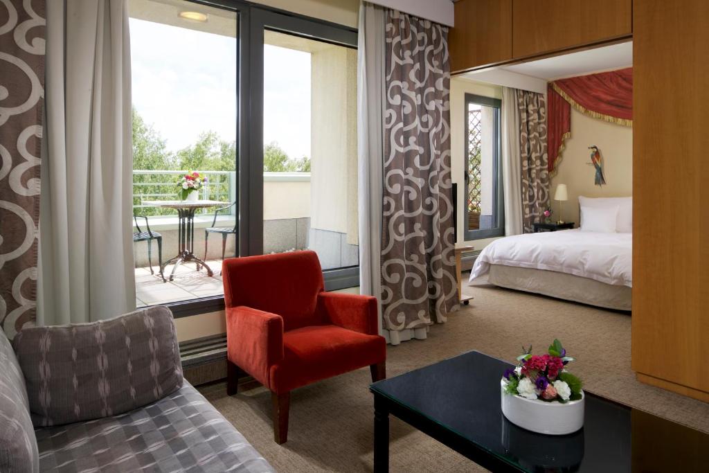 a hotel room with a bed and a chair at Hotel Parc Belair in Luxembourg