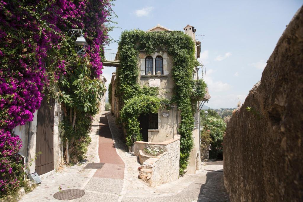 Une allée avec des fleurs sur le côté d'un bâtiment dans l'établissement La Miette, à Vence