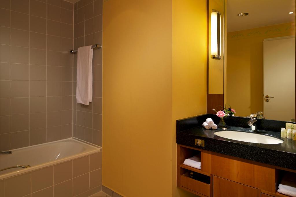 a bathroom with a sink and a bath tub at Hotel Parc Belair in Luxembourg