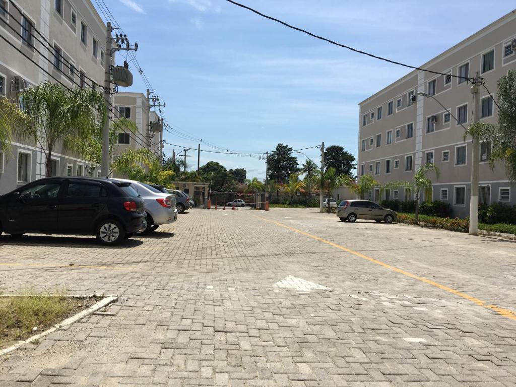 un estacionamiento con autos estacionados frente a un edificio en Apartamento-Excelente localização, en Resende