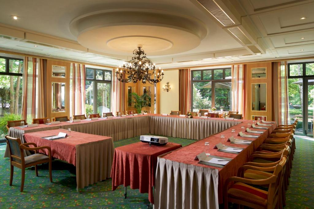 a large room with tables and chairs and a chandelier at Hotel Parc Belair in Luxembourg