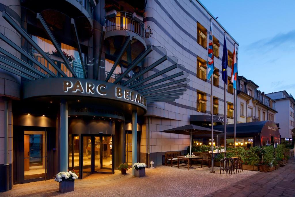 een groot gebouw met een restaurant ervoor bij Hotel Parc Belair in Luxemburg