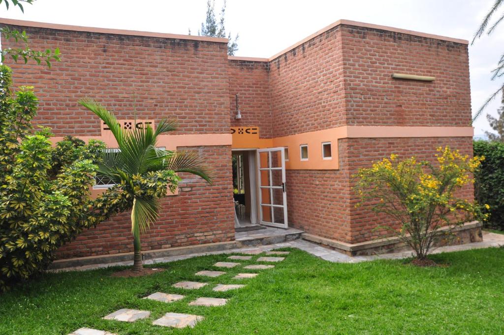uma casa de tijolos com um relvado em frente em Salama Village em Kigali