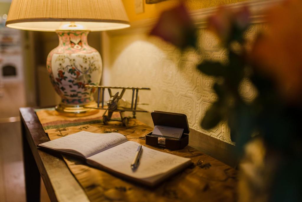 a desk with a lamp and a notebook and a pen at Cheriton Guesthouse in Sidmouth