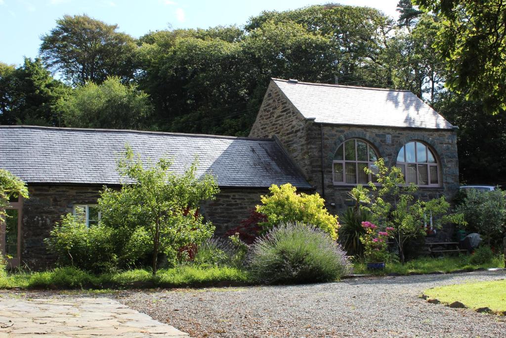 una casa de piedra con un jardín delante de ella en Yr Hen Feudy, en Barmouth