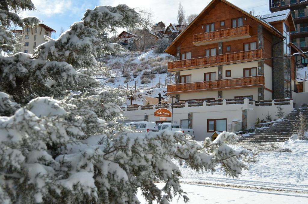 um edifício com árvores cobertas de neve em frente em Hotel Chalet Valluga em Farellones