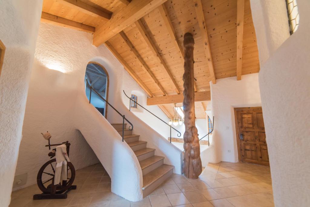 a staircase in a house with a wooden ceiling at Jagerhof in Caldaro