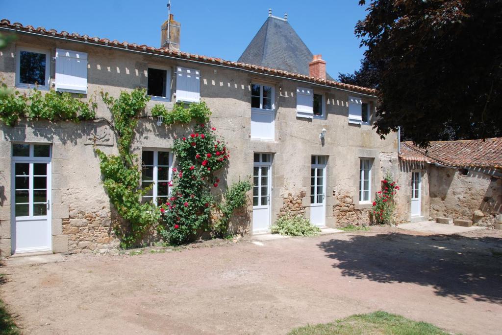 un vecchio edificio in pietra con dei fiori sopra di Château de Touvois a Maulévrier