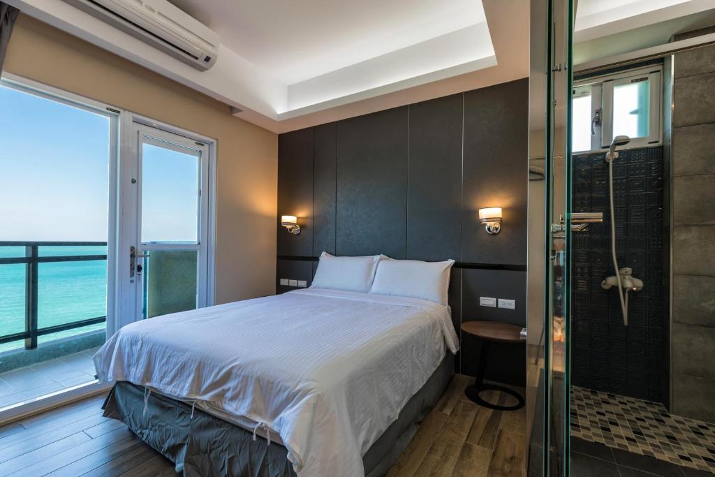 a bedroom with a bed and a glass shower at Jia Xiang Lin Guan Hai Homestay 2 in Magong
