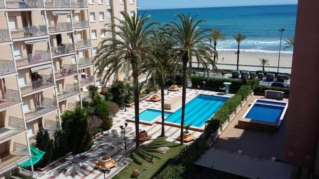 セグル・デ・カラフェルにあるSea front Apart. 2 Pools / 1ª linea. 2 piscinasのスイミングプールとビーチのあるホテルの空からの景色を望めます。