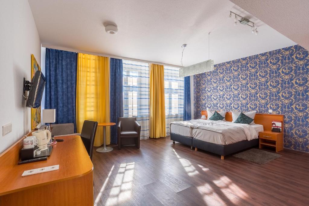 una camera d'albergo con letto e scrivania di Hotel Bayrischer Hof a Heidelberg