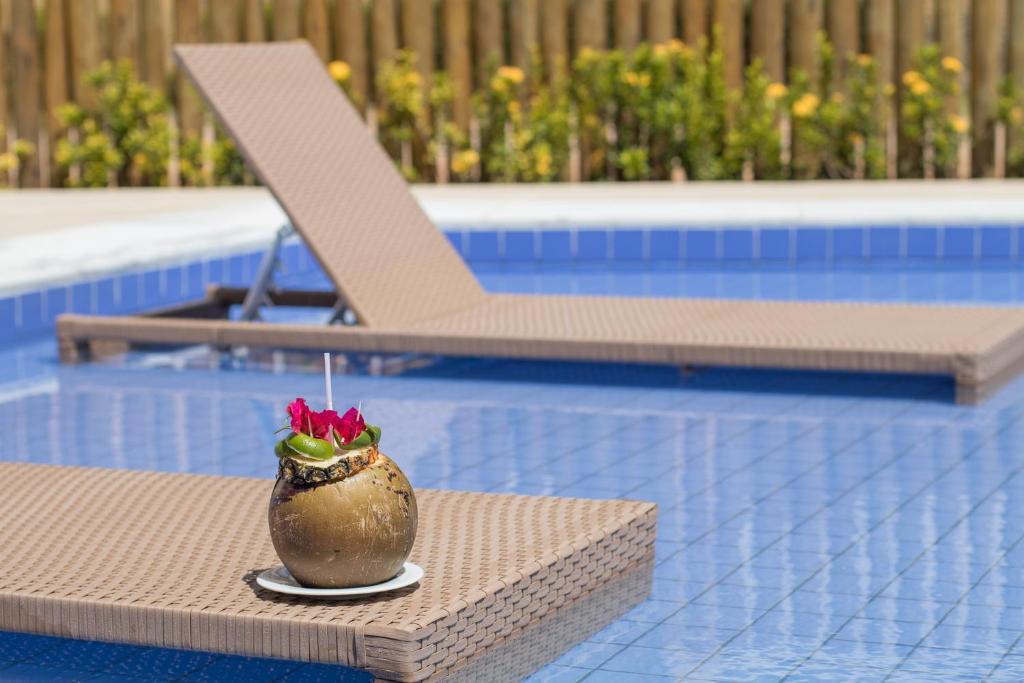 a vase sitting on a table next to a swimming pool at Wave Suítes Hotel & Lounge bar in Maceió