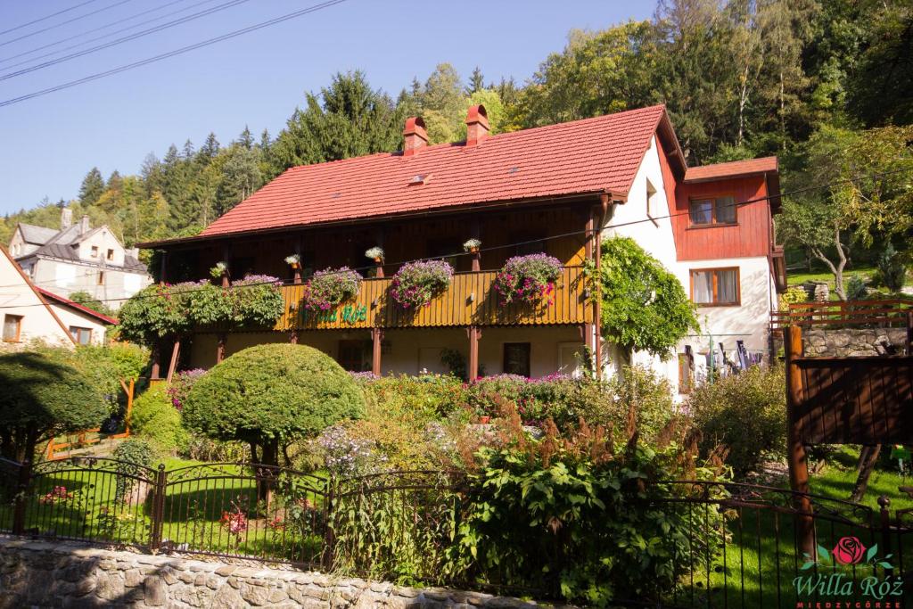 a house with a balcony with flowers on it at Willa Róż w Międzygórzu in Miedzygorze