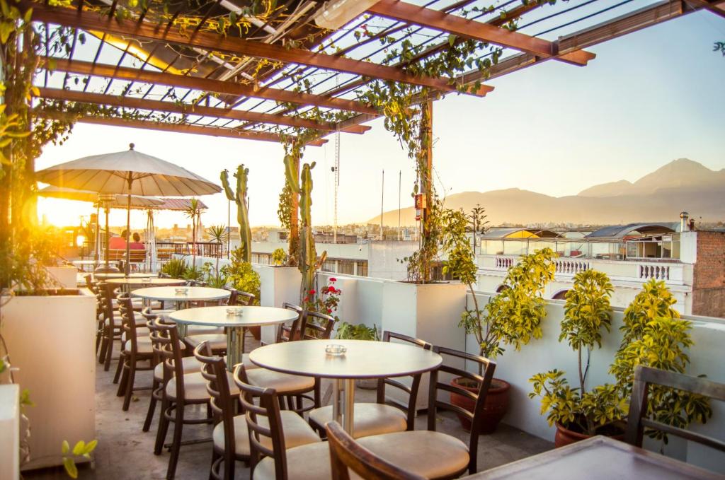 - une rangée de tables et de chaises sur le toit-terrasse dans l'établissement Le Foyer Arequipa, à Arequipa