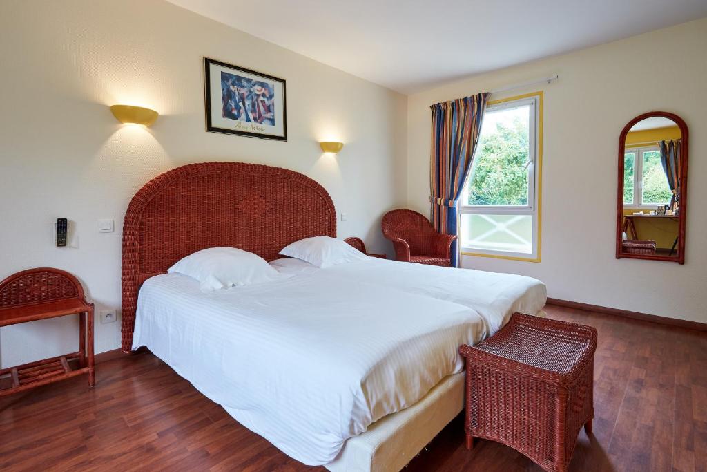 a hotel room with a bed and a desk at Domaine de L'Hostreiere in Colleville-sur-Mer