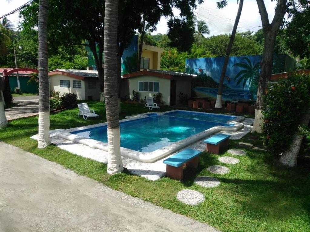 a swimming pool with a slide in front of a house at Hotel y Restaurante Rincón Familiar in La Libertad