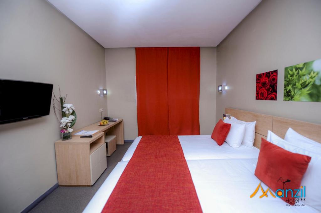 Postel nebo postele na pokoji v ubytování Manzil Hotel