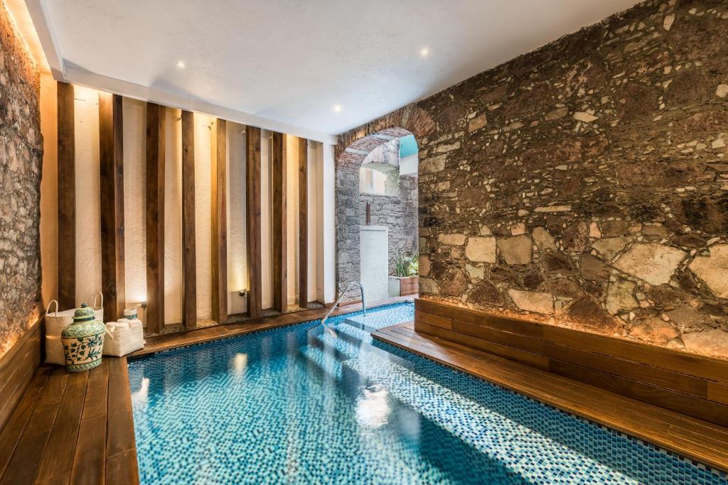 una piscina en una habitación con una pared de piedra en Edelmira Hotel Boutique, en Guanajuato