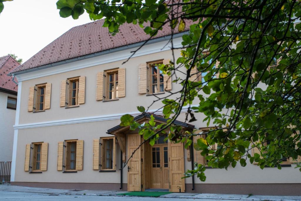 un edificio con ventanas de madera con contraventanas y techo en Vila Viktorija en Brod na Kupi