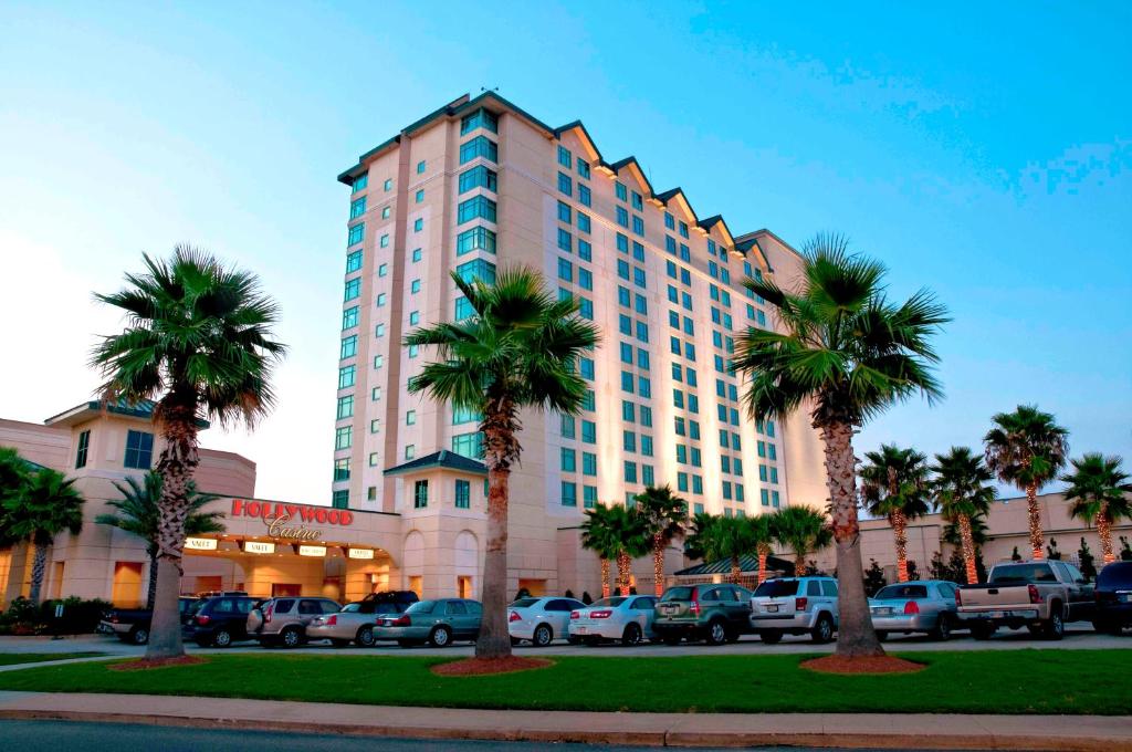 een groot gebouw met palmbomen op een parkeerplaats bij Hollywood Casino - Bay Saint Louis in Bay Saint Louis