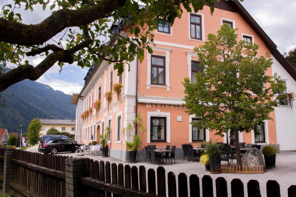 a pink building with a fence in front of it at Gasthof zum Richter in Mühldorf