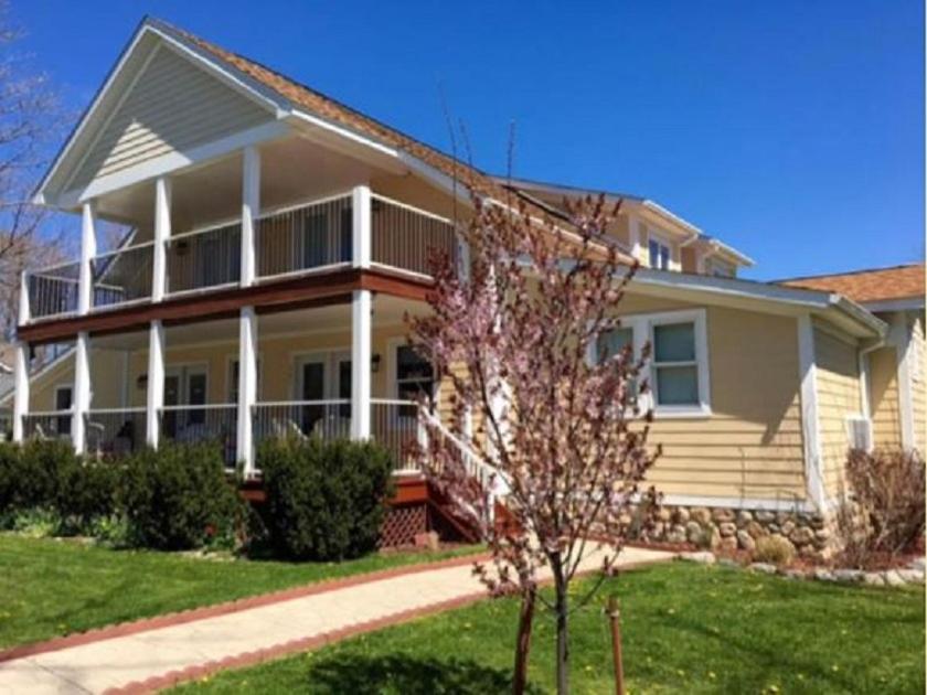 una grande casa bianca con un albero di fronte di Ahoy Inn Guesthouse a Put-in-Bay