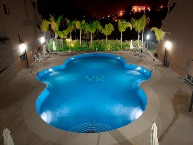 una gran piscina azul en un edificio por la noche en Luxury Residence Puerto Banus, en Marbella