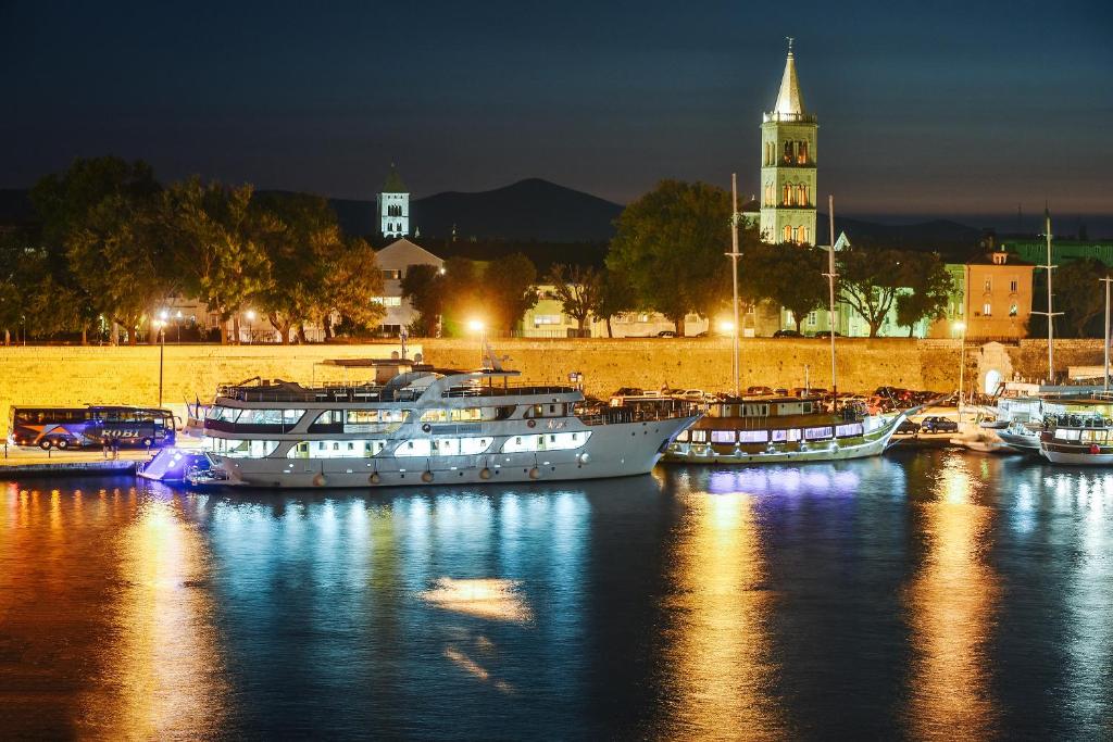 een groep boten aangemeerd in een haven 's nachts bij Magic View Apartments in Zadar