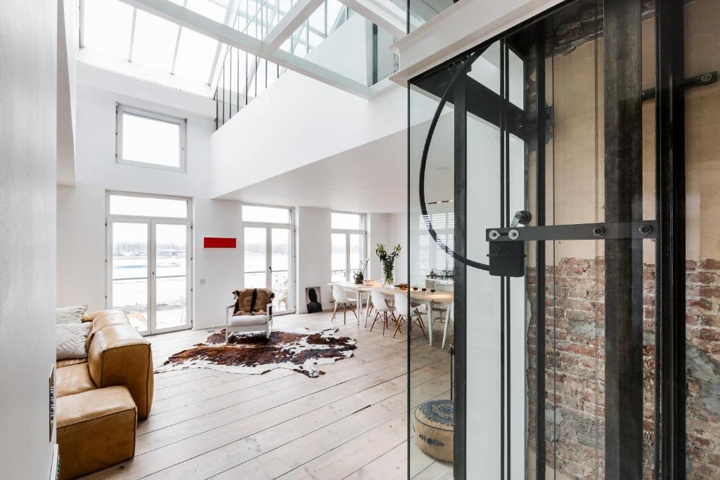 - un salon avec une porte en verre menant à une salle à manger dans l'établissement Loft O - River View, à Anvers