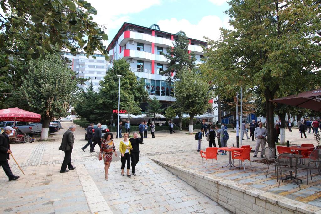 un grupo de personas caminando por una calle de la ciudad en Hotel Piazza en Peshkopi