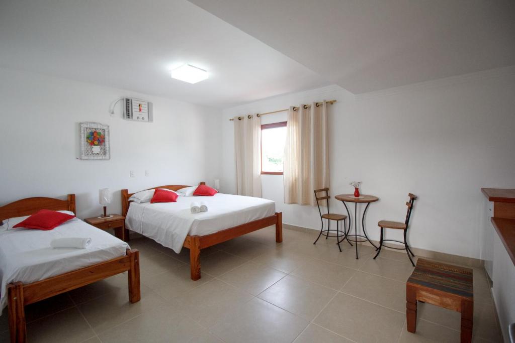 een slaapkamer met 2 bedden en een tafel en stoelen bij Pousada Acqua Azul in Bertioga