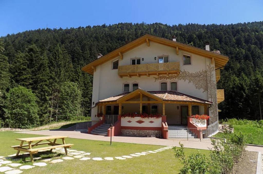a large house with a picnic table in front of it at Genzianella Mansarda Molveno-Andalo in Molveno