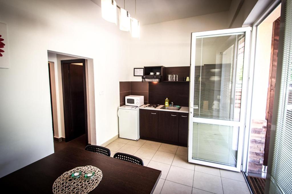 a kitchen with a dining table and a kitchen with a refrigerator at Apartmány Sázavský ostrov in Sázava