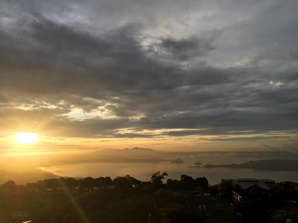 a view of a sunset with the sun in the sky at Ron's Condo Overlooking the Lake in Tagaytay