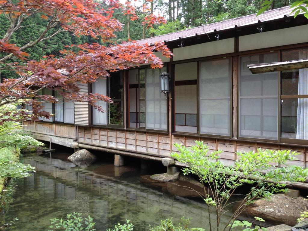 uma casa sobre uma ponte sobre um riacho em Takimi Onsen Inn that only accepts one group per day em Nagiso